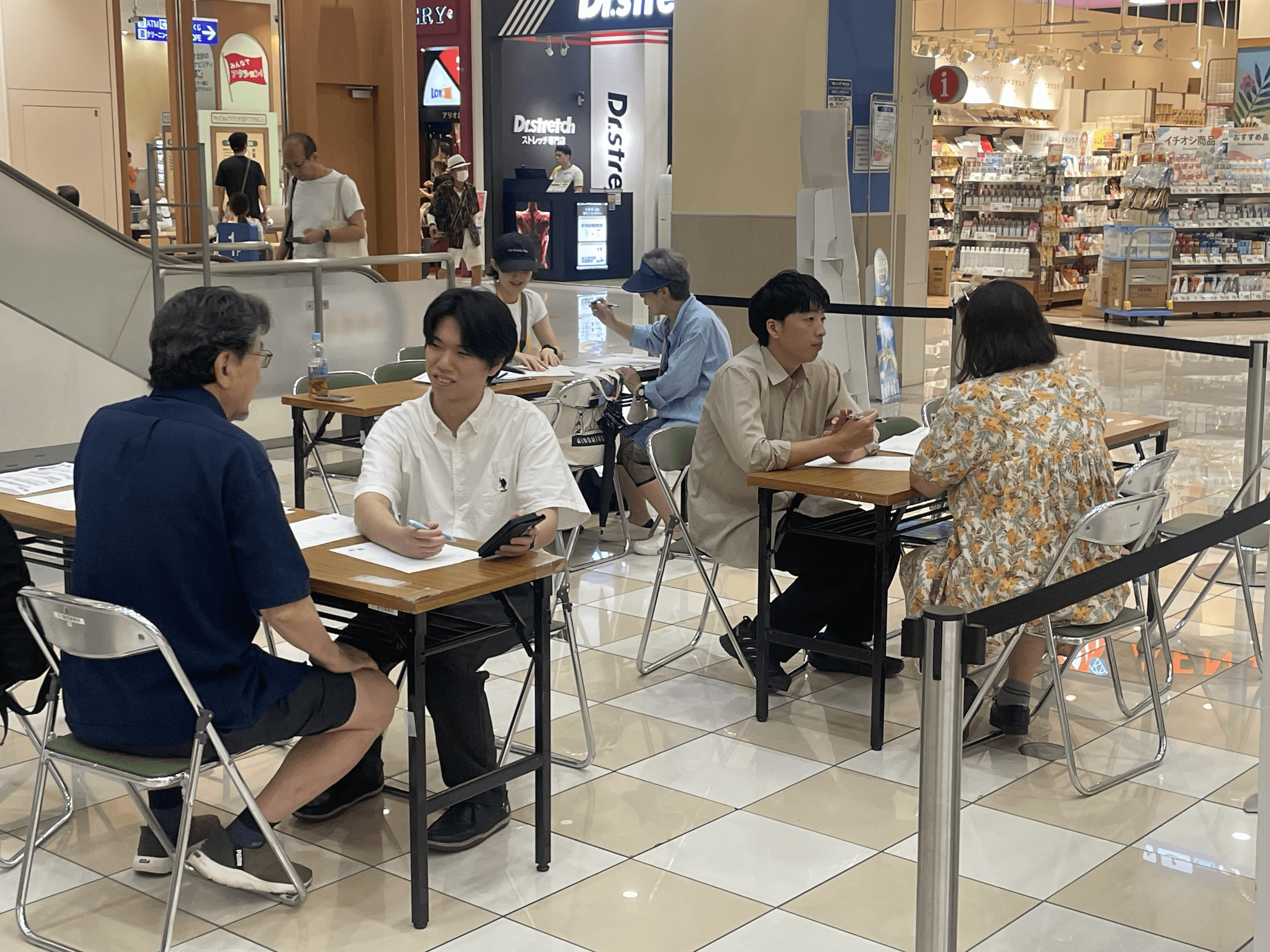 参加者とスタッフがテーブルでスマートフォンを操作している様子